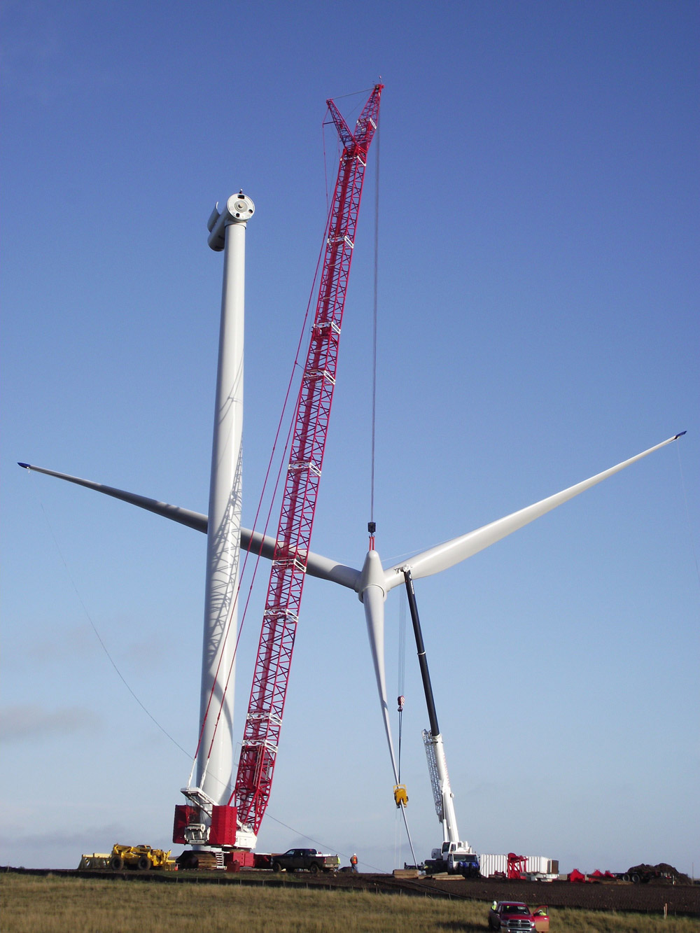 The blades are raised by crane to be attached to the nacelle.